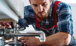 Man plaid shirt is working sewing machine