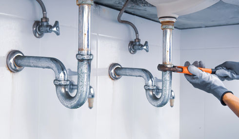 Technician plumber using wrench repair water pipe sink