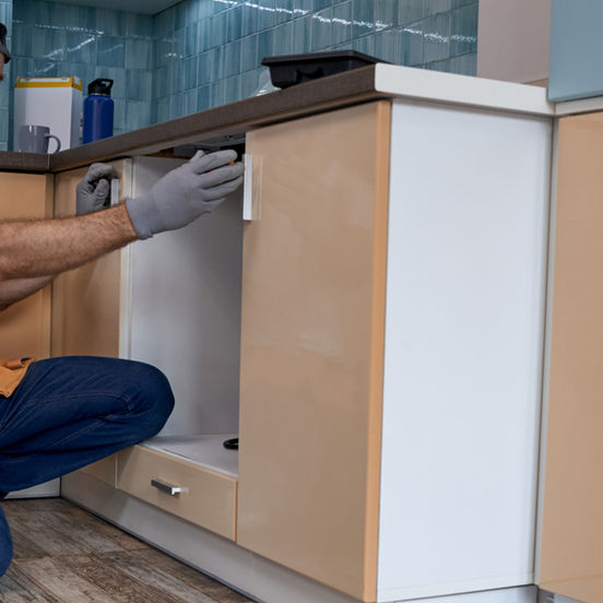 Young caucasian worker measuring drawer kitchen furniture